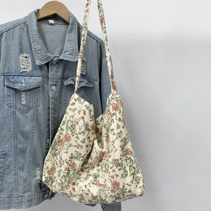 Floral canvas shoulder bag on a denim jacket showing chic crossbody bag style