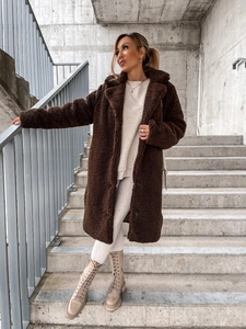 Close-up of deep brown teddy coat fabric and warm plush texture with oversized lapels