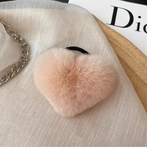 Macro view of a soft pink plush heart hair tie with high-elasticity rubber band