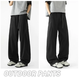 Detalle de pantalón negro de exterior holgado con pernera ancha y cinturón largo