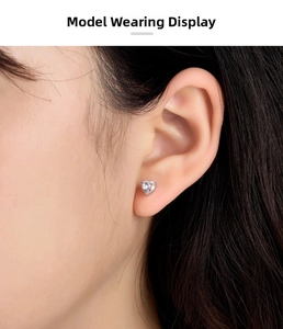 Close-up of 925 sterling silver heart-shaped stud earring with cubic zirconia on model ear
