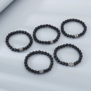 Close-up of five black volcanic rock beaded bracelets with silver alloy charms