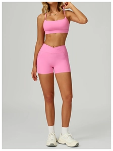 Detail view of pink yoga shorts with cross-waist design and practical side pockets