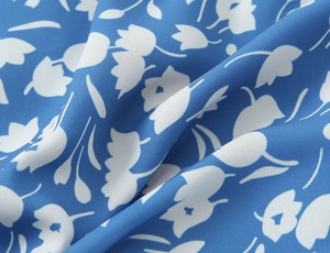 Vue macro détaillée du tissu en mousseline bleue avec imprimés floraux blancs et texture