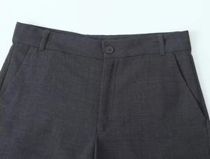 Détail du pantalon de costume gris foncé avec fermeture à bouton et passants de ceinture