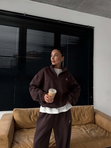 Detail of dark brown half-zip sweatshirt with stand collar and matching sweatpants set