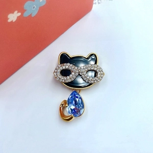 Macro shot of cute cat brooch with blue crystal body and sparkling rhinestone eyes