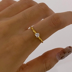 Close-up of a gold-tone stainless steel ring featuring a heart-shaped zircon stone