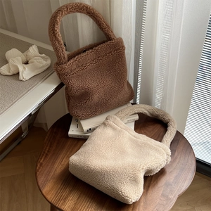 Close-up of fuzzy teddy tote bags in brown and beige on a wooden table setup