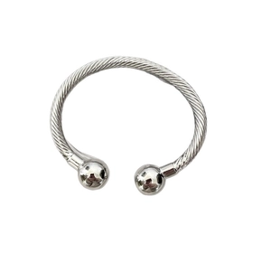 Elegant twisted silver cable cuff bracelet with sphere end caps in minimalist style