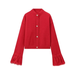 Rote Strickjacke mit Pelzbesatz am Ärmel und goldenen Knöpfen auf weißem Hintergrund
