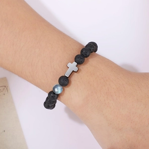Vue détaillée d'un bracelet en pierre de lave de 8 mm avec pierre de lune et croix au poignet