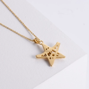 18K gold star pendant necklace with hollow punk skull design on white geometric stone