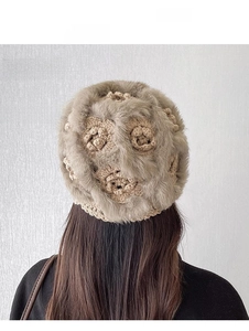 Detail of winter knit beanie with thick rabbit fur trim and 3D floral crochet patterns