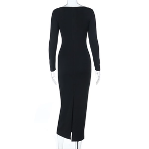 Detail view of the back of a slim fit black maxi dress with a rear slit and long sleeves