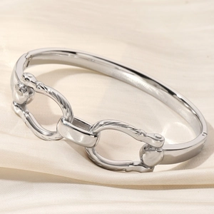 Polished silver double-ring bracelet with spiral texture on elegant beige silk background
