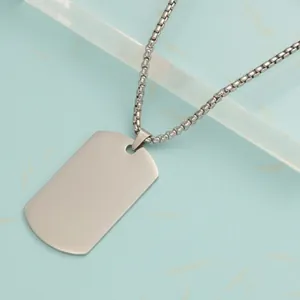 Macro view of a matte stainless steel rectangular dog tag pendant on a link chain