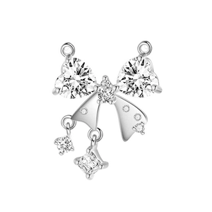 Macro view of silver bow pendant with shimmering heart and pear-shaped zircon stones