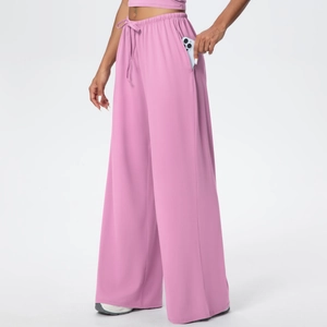 Detail of wide-leg trousers showing deep side pocket with phone and drawstring waist