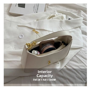 Interior view of off-white shoulder bag showing capacity for phone and cosmetics