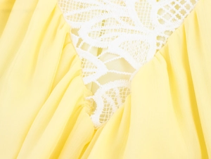 Détail du tissu en mousseline jaune avec dentelle blanche délicate et design ajouré