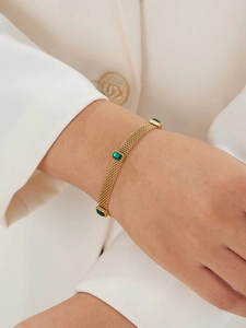 Détail du bracelet en maille dorée vintage avec pierres précieuses vertes rectangulaires