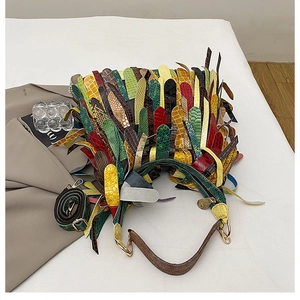 Detail of bohemian patchwork leather bag with diverse animal textures and colorful fringes