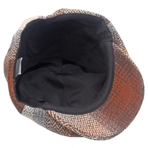 Detailed macro view of the interior lining and herringbone wool texture of newsboy cap