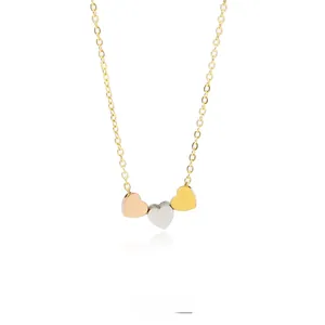 Detailed view of tricolor heart pendants in rose gold silver and gold on a thin chain