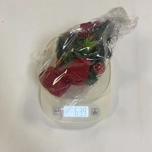Detailed view of mini Christmas tree weighing 63.9g on a digital scale for desktop decor