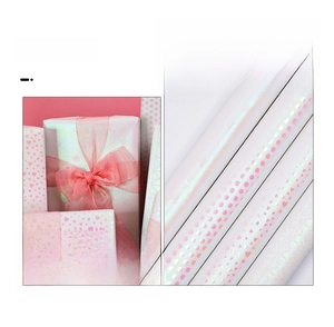 Detail of pink iridescent gift wrap with laser heart and polka dot patterns for birthdays