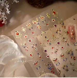 Macro shot of M-1324 gold phoenix nail stickers with red glitter and floral patterns