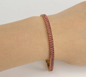 Detail eines 18K vergoldeten Tennisarmbands mit rosa rechteckigen Zirkonia-Steinen