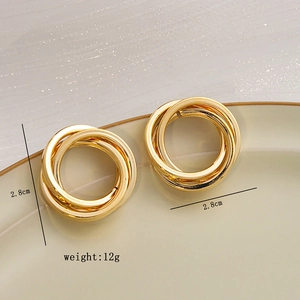 Detailed view of 2.8cm golden triple interlinked hoop earrings with mirror finish
