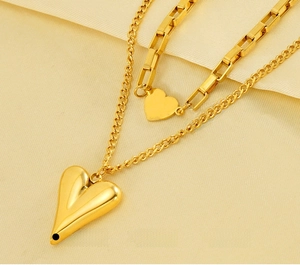 Detail of double-layered stainless steel gold heart necklace with dual chain styles