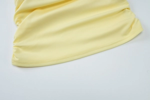 Vista detallada de la costura de doble aguja en el dobladillo de punto amarillo claro