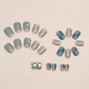 Press-on nails with green gradients, marble patterns, and sparkling rhinestones