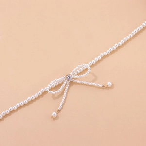 Detail of pearl bow necklace with crystal center and elegant hanging fringe strands