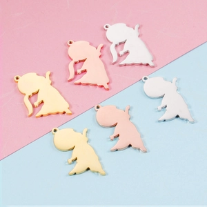 Flat lay of six cartoon silhouette pendants in gold, rose gold, and silver stainless steel