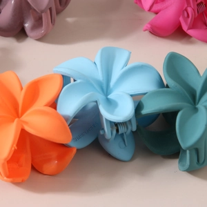 Macro shot of 4cm matte flower hair claws in candy colors with detailed metal spring mechanism