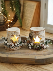 Detail of wooden star-cutout candle holders with pine cones and cozy LED lighting decor