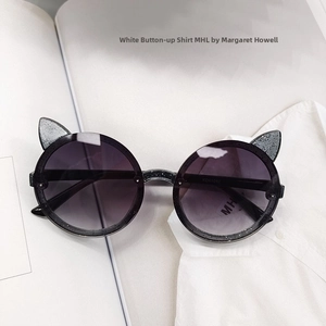 Detail of round cat ear sunglasses with black glitter frames and purple gradient lenses