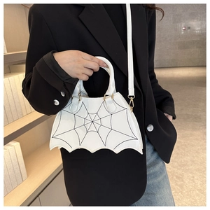 Detail of white bat-shaped handbag with black spiderweb stitching and gold hardware