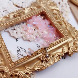 Detail showing pink iridescent butterfly earring with screw ball back on vintage frame