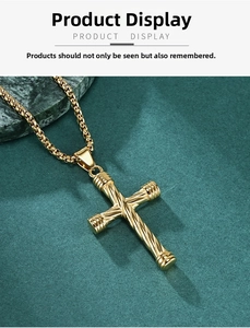 Close-up of golden cross pendant with twisted texture on elegant green surface