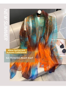 Detail of turquoise and orange gradient chiffon shawl with bird and tree branch patterns