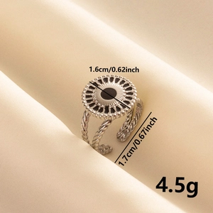 Detailed view of vintage stainless steel ring with black enamel sunburst and twisted band