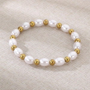 Détail macro du bracelet perles d'eau douce et billes dorées avec fermoir TO sur lin