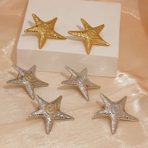 Starfish ocean earrings in gold and silver with hammer texture on silk background