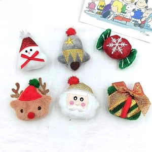 Detail view of plush Christmas brooches featuring snowman, reindeer and Santa embroidery